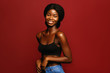 © Beauty Agent Studio - Beauty. African American beautiful woman portrait. Brunette curly haired young model with dark skin and perfect smile against red background