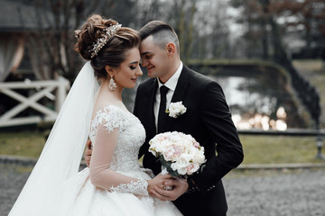 Loving wedding couple outdoor. Bride and groom. Bride and Groom at wedding Day walking Outdoors. Bridal couple, Happy Newlywed woman and man embracing and kissing in park. 