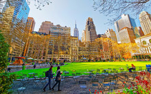 Tourists Looking At Green Lawn In Bryant Park In Midtown Manhattan, New York, USA. United States Of America. NYC, US. Skyline With Skyscrapers And American Cityscape.