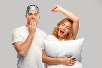 Sticker - relationships and people concept - couple in white t-shirts with eye sleeping mask and pillow yawning and stretching over grey background