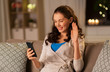 © Syda Productions - technology, online communication, internet and people concept - smiling young woman with smartphone having video call at home in evening