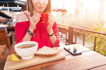 Wall Mural - Asian woman eating hot vegetarian soup in cafe. Healthy diet and dinner concept