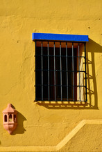 Traditional  Window With Bars In Yellow Wall In Andalusia, Spain.