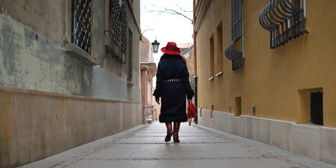 Wall Mural - Elegant woman in a red hat in the old town of Warsaw.Stay at home