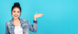 © ChayTee - Banner of Happy asian woman feeling happiness and gesture hand open on blue background. Cute asia girl smiling wearing casual jeans shirt and present on copy space.