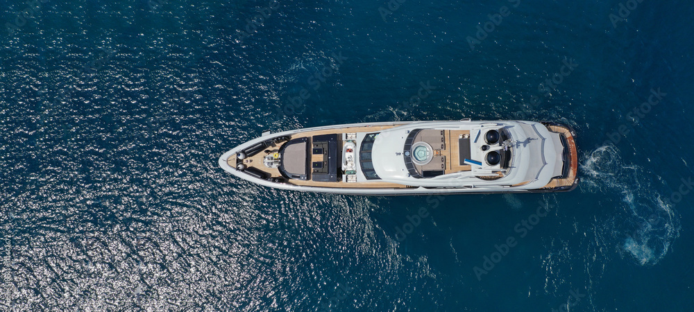 Aerial drone ultra wide photo of luxury yacht with wooden deck docked near port of Port of Fontvieille in deep blue sea, Monaco, France - obrazy, fototapety, plakaty 