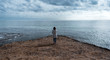 © Cavan Images - Young woman looking towards the horizon, she is at the end of a