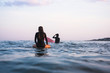 © Cavan Images - Water women friends surfing together at sunset