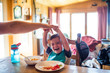 © Cavan Images - Father reach to tickle his son while at the table