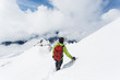 © Cavan Images - A young man descends from the summit of Mt. Hood on a cloudy day.