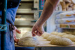 © Cavan Images - Close-up of a baker preparing seeded bread dough for the oven
