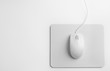 Modern wired optical mouse and pad on white background, top view