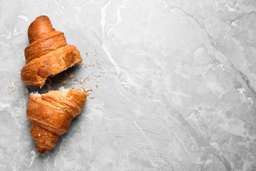 Wall Mural - Tasty fresh croissant on light grey marble table, flat lay. Space for text