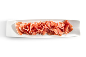 Canvas Print - Sliced Jamon Iberico, Prosciutto or Speck on Restaurant Plate Isolated