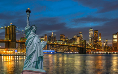Fototapete - The Statue of Liberty over the Scene of New york Cityscape with Brooklyn Bridge beside the east river at the twilight time,Architecture and building with tourist concept, United state of America, USA