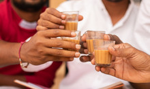 Close up of hands cheers Tea glasses - concept showing group of friends enjoying morning Tea by cheering at Hotel.