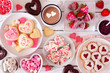 © Jenifoto - Valentines Day table scene with a selection of sweets and cookies. Top view over a white wood background. Love and hearts theme.