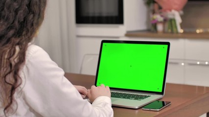 Woman using laptop computer with laptop green screen, 4K shot. Technology, chroma key, template, mockup and entertainment concept.