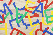 Colorful Jumbled Letters, Made Of Paper,  Lying On Wood