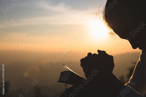 Woman praying in the morning on the sunrise background. Christianity concept. Pray background. Faith hope love concept.