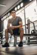 © sarayutsridee - Young fitness man sitting in gym. asian sport man sitting and looking to outside in sportclub.