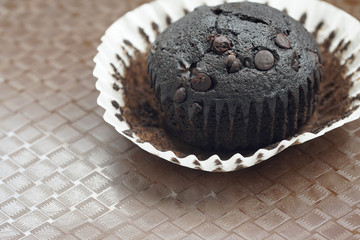 Close up on a homemade chocolate muffin with chocolate chip on top.