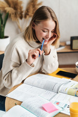 Wall Mural - Photo of smiling attractive woman making notes in exercise book