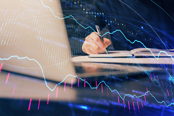 Double exposure of businessman with laptop and stock market forex chart.