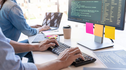 Wall Mural - young startup programmers sitting at desks working on computers screen for developing programming an
