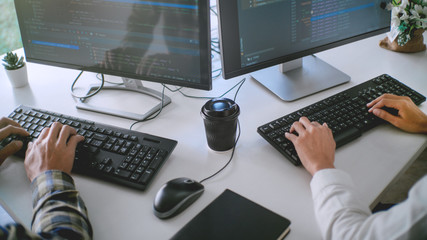 Wall Mural - young startup programmers sitting at desks working on computers screen for developing programming an