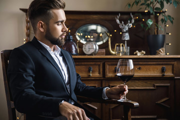 Wall Mural - Handsome bearded man with a glass of red wine