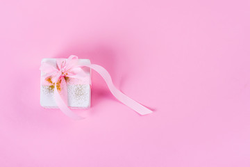 Canvas Print - White gift box tied with pink ribbon on pink pastel background with copy space