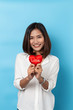 © suriya - Love and valentines day, asian girl holding red heart shape isolated on blue background