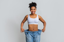 Happy Young Woman With Too Large Jeans