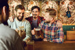 © Studio Romantic - Group friends clinking glasses of beer in a bar.