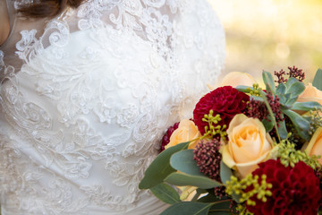 Détail de la robe de la marié le jour du mariage avec son bouquet