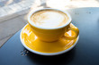 © Boumenjapet - A yellow cup of coffee on the table. A fresh morning coffee time in downtown street cafe.