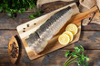 Hot smoked sturgeon on a wooden Board on a brown wooden table. Top view with copy space. Rustic style