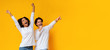 Leinwandbild Motiv Multiracial couple dancing and singing together, having fun over yellow background