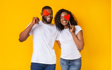 Wall Mural - Playful afro lovers closing one eye with red love hearts