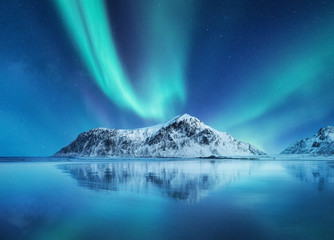 Wall Mural - Aurora Borealis, Lofoten islands, Norway. Northen lights, mountains and reflection on the water. Winter landscape during polar lights. Norway travel - image