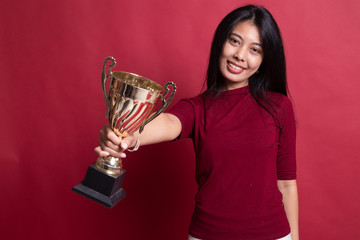 Wall Mural - Successful young asian woman holding a trophy.