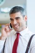 © MDBPIXS - Close-up of businessman smiling on mobile phone