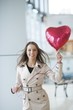 © moodboard - Businesswoman holding heart shaped balloon and smiling