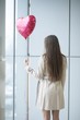 © moodboard - Woman with back to camera holding heart shaped balloon