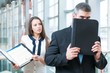 © moodboard - Businessman hides from coworker behind folder