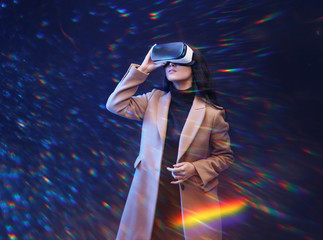 Wall Mural - beautiful woman in fashionable clothes over dark background. girl in glasses of virtual reality. aug