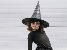 Girl Dressed As A Witch With A Painted Face Looking At Camera