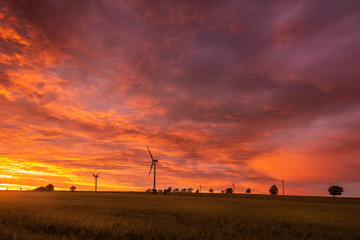 Fields with windmill for electric power production at sunset time. Polish countryside. Europe