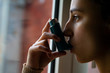 © DALU11 - Young woman taking the blue asthma inhaler to treat an asthma attack.